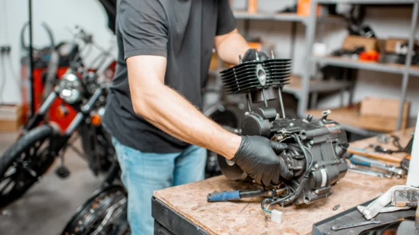 mężczyzna dokonuje regeneracji części silnika